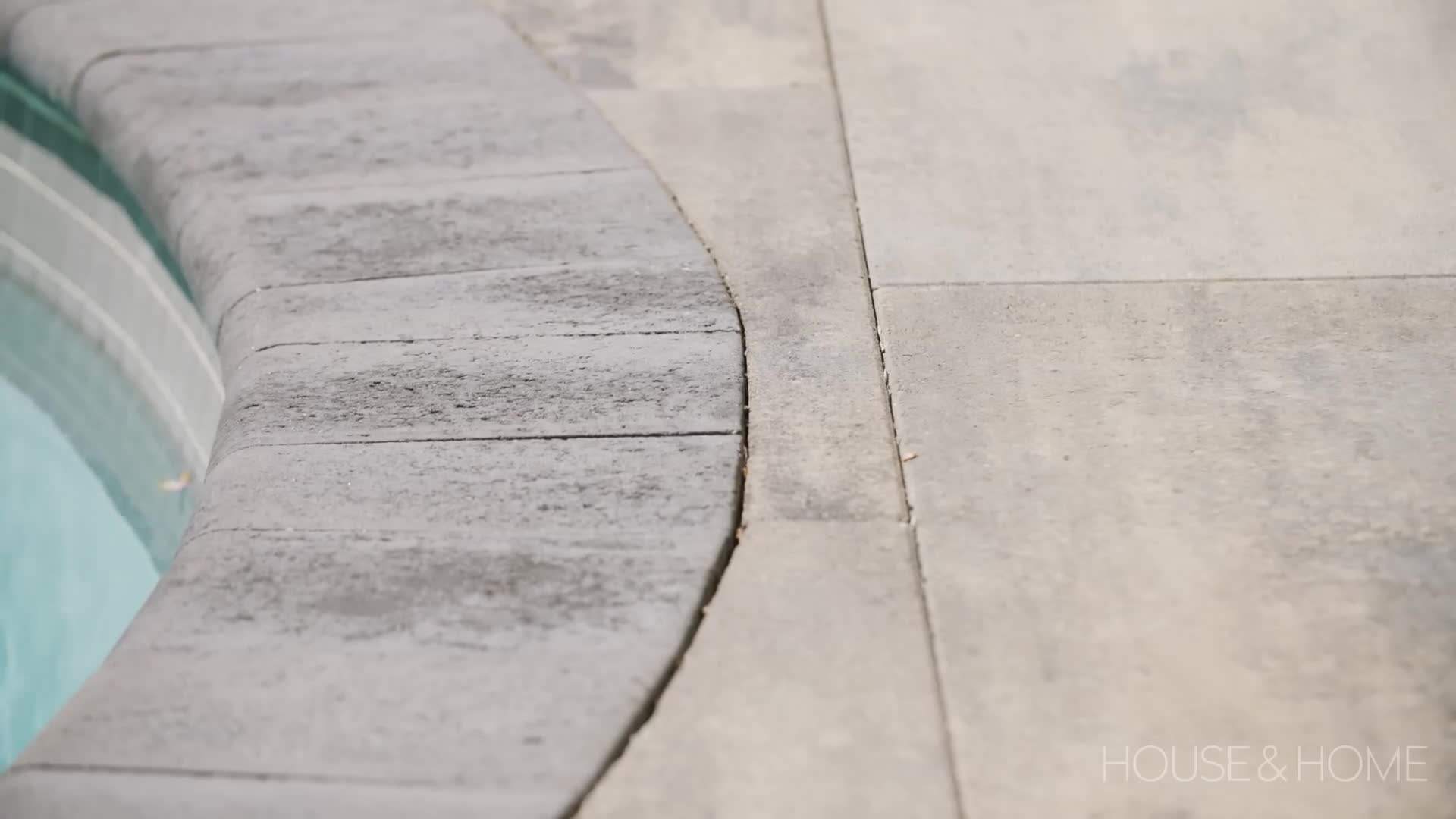 The renovated pool with modern tiles, a sleek water feature, and LED lighting
