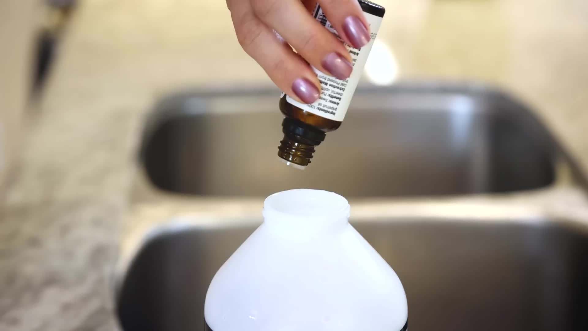 Mixing white vinegar, water, and essential oils to create an all-purpose cleaner