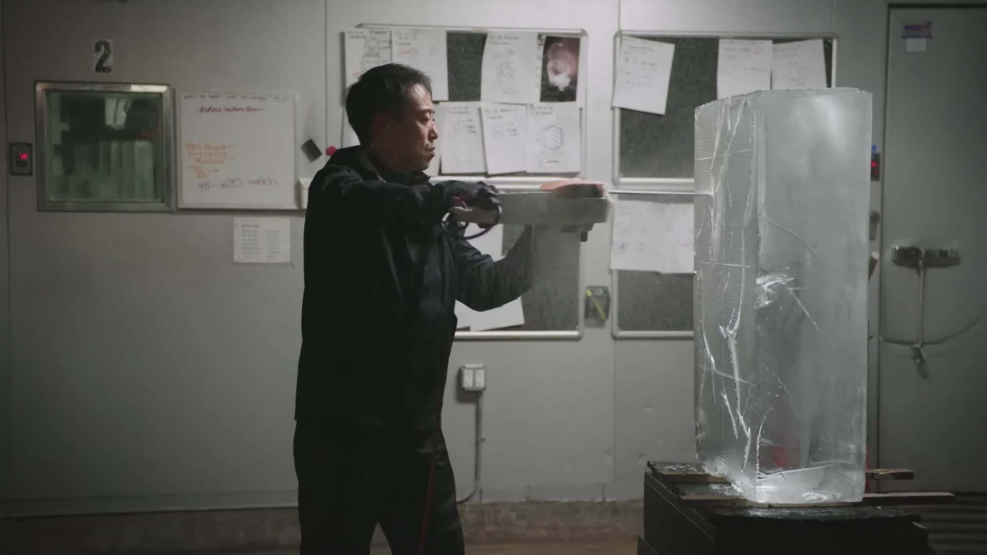 Shintaro Okamoto using a chainsaw to shape the ice
