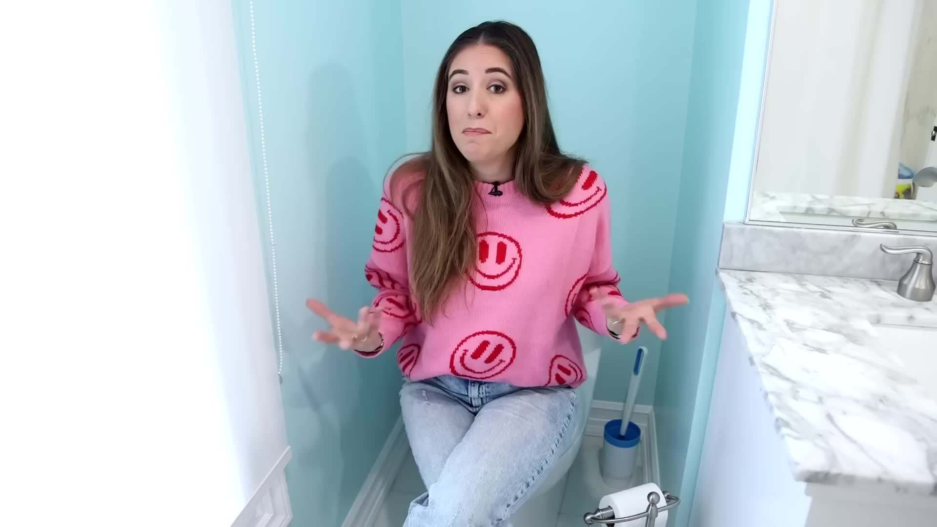 A person wearing gloves and using cleaning wipes in the bathroom