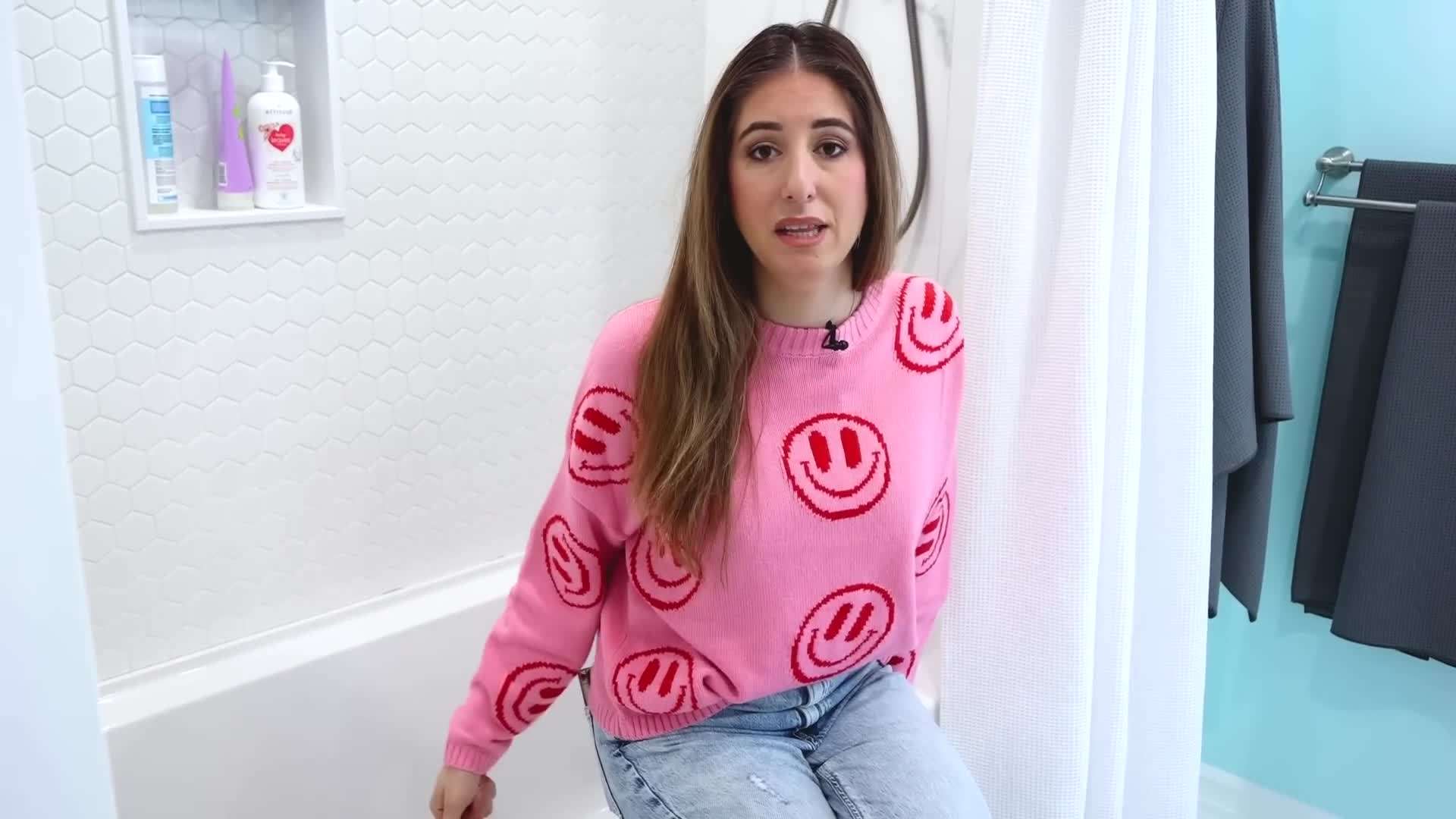 A person using a scrub brush to clean the bathtub