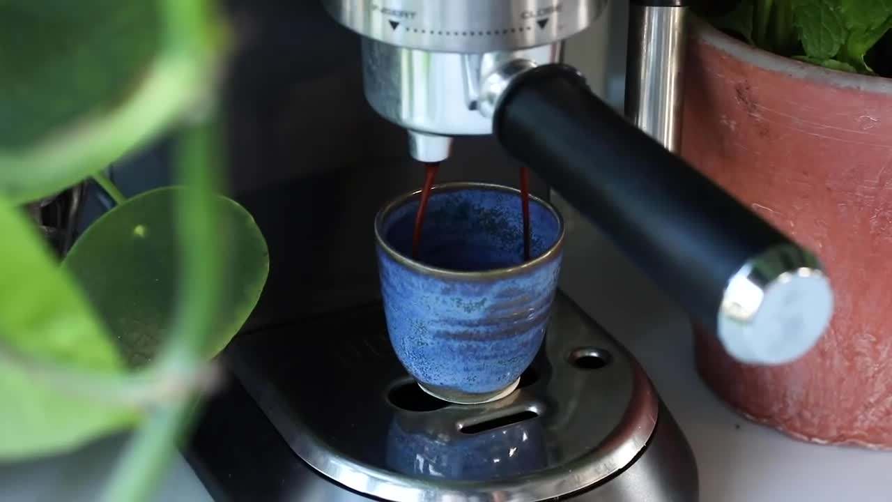 A steaming cup of peppermint tea with a fresh mint leaf