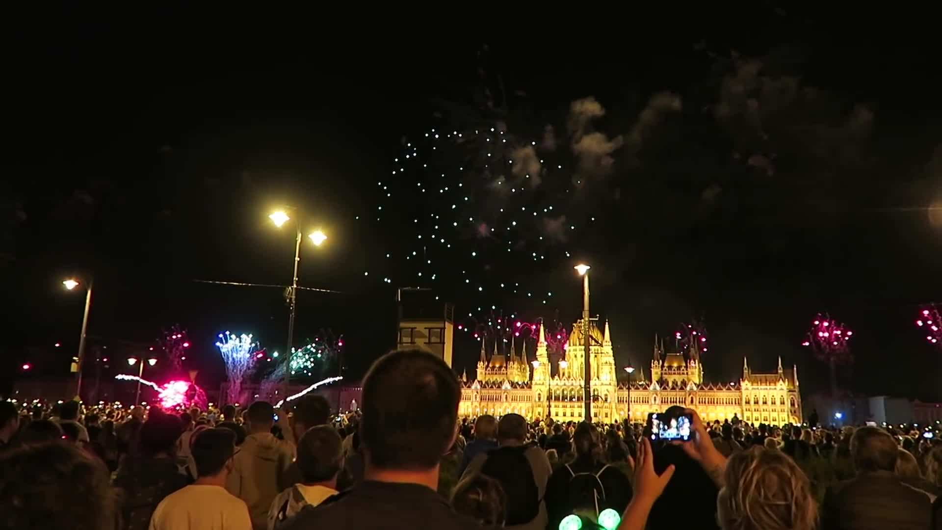 A panoramic view of Budapest's Chain Bridge illuminated by fireworks.