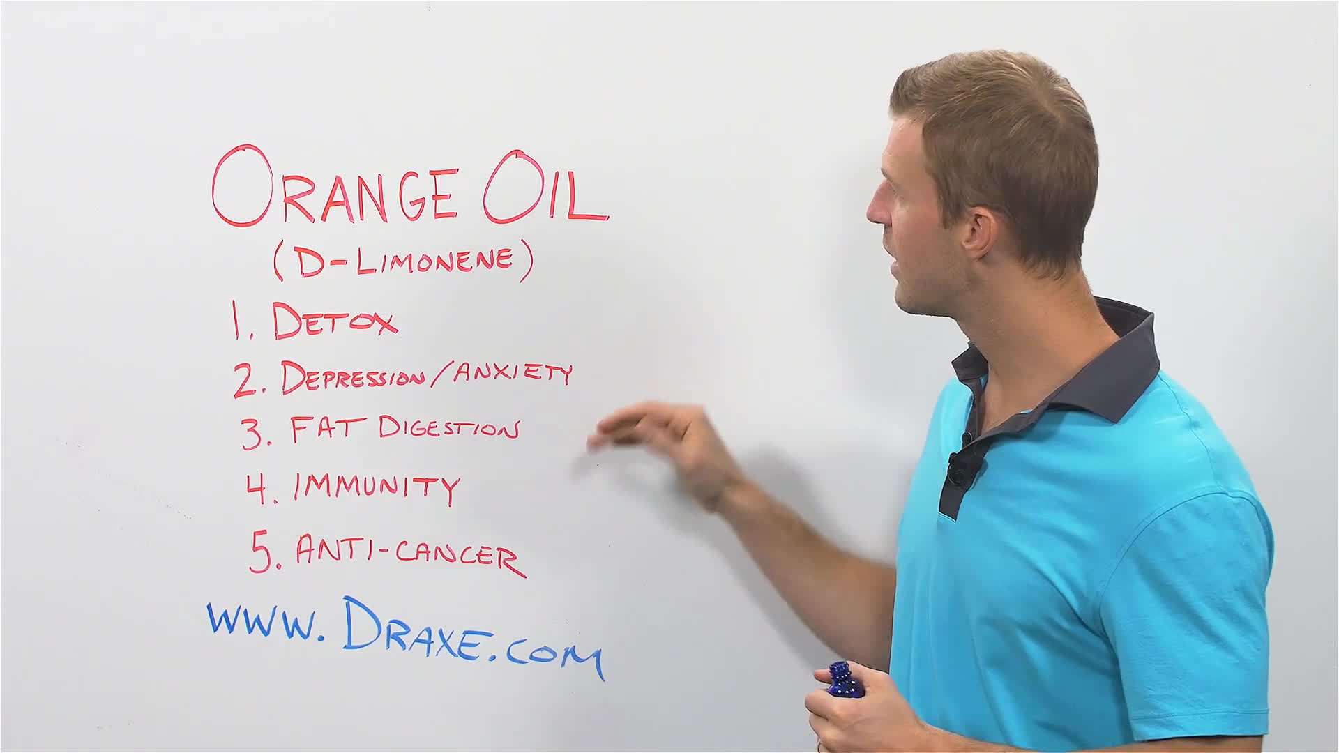 Woman applying orange essential oil on face