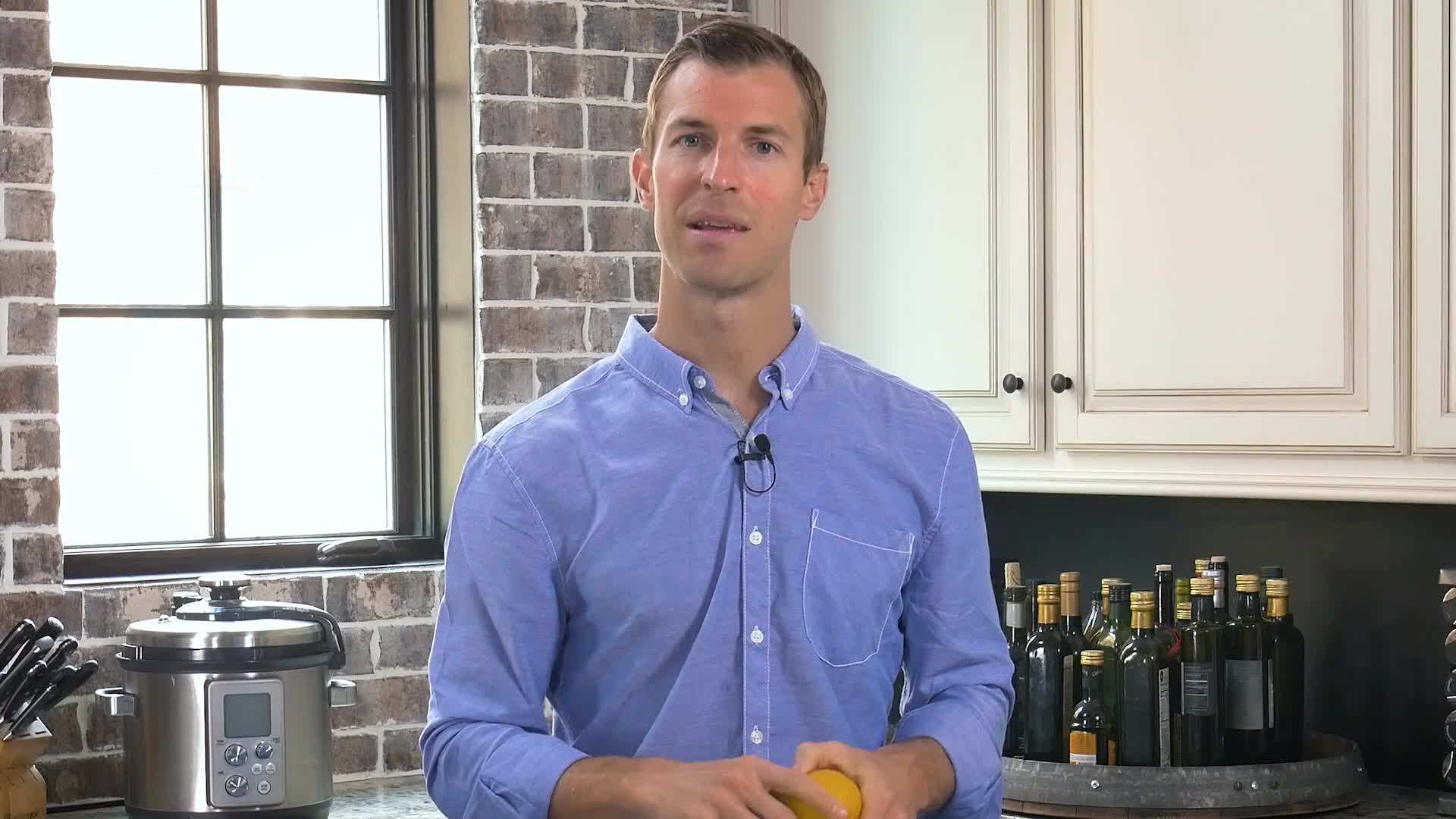 Fresh lemon being squeezed into a glass of water