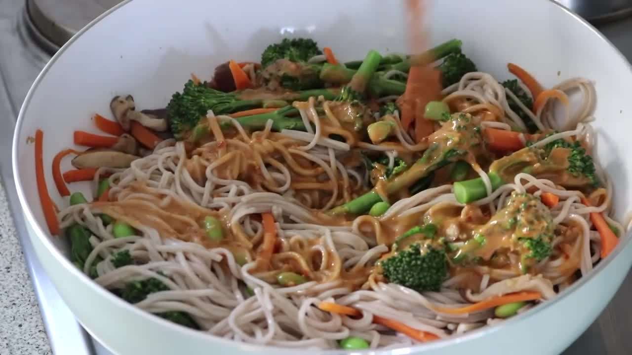 Bento box with tempeh skewers, crispy tofu, quinoa, edamame, and fresh vegetables