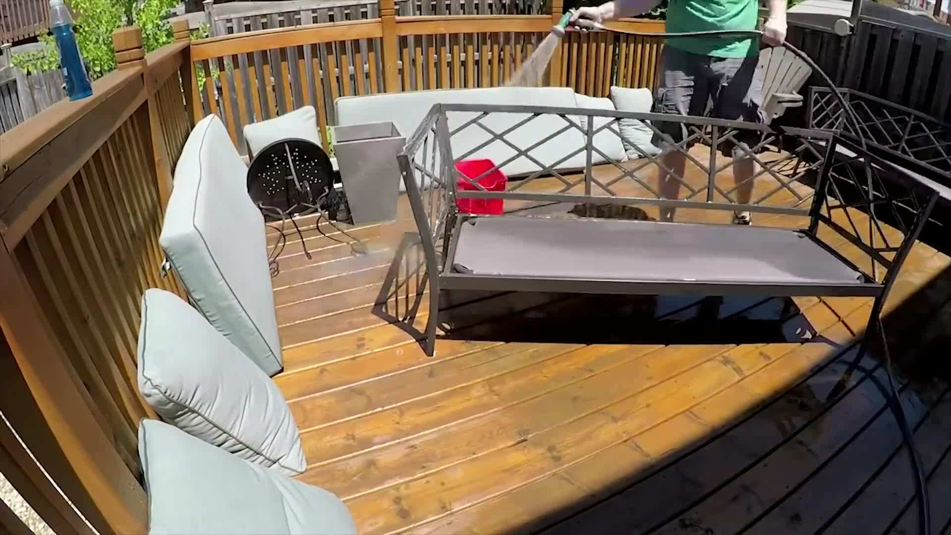 Cleaning outdoor garbage and recycling bins with hot soapy water