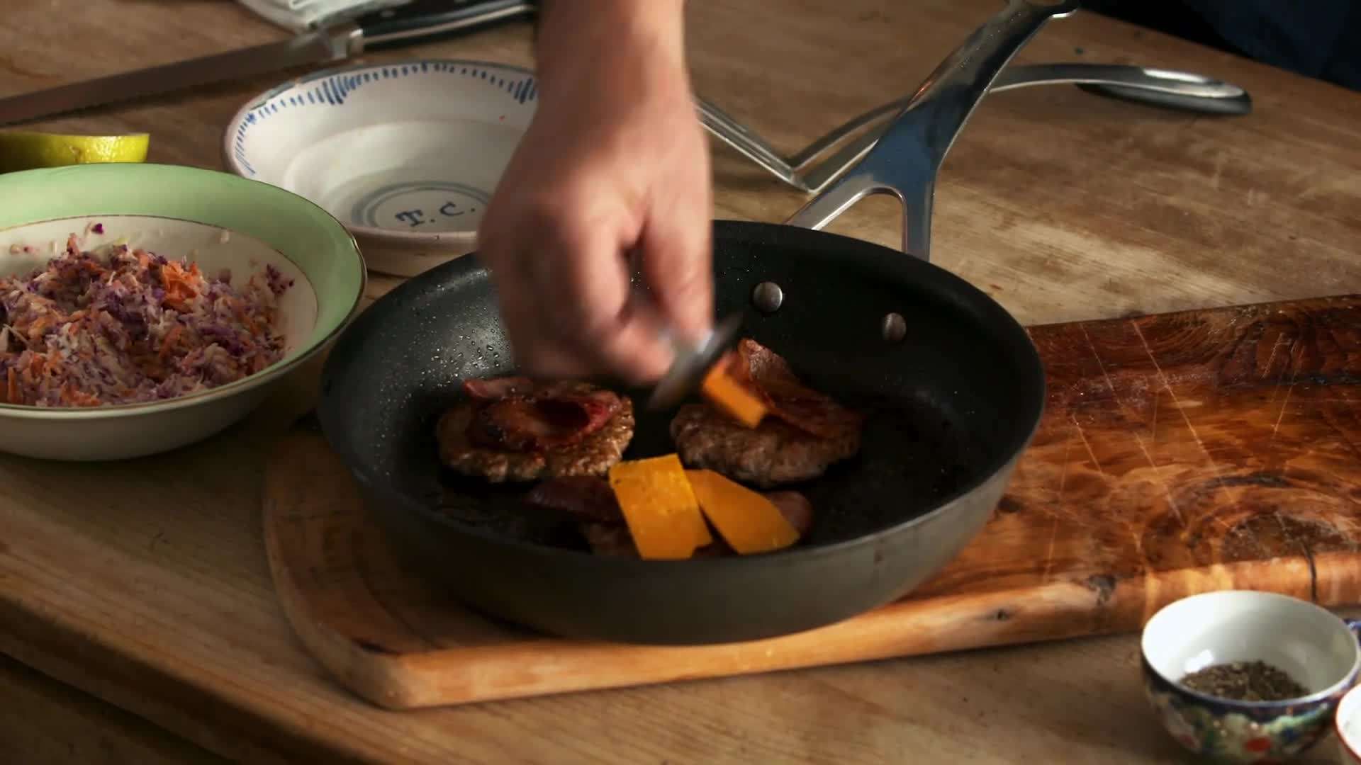 Layering crispy bacon on the burger