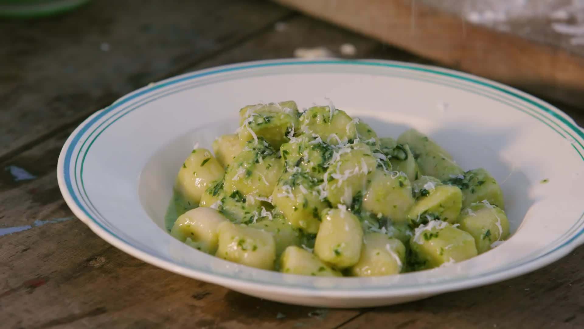 Grating Parmesan cheese over the finished dish